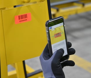 Mit dem Smartphone und der A+W Smart Companion Software wird ein Barcode von einer Glasscheibe eingescannt.