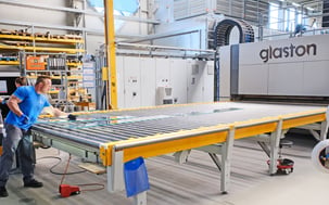 An employee stands at the ESG furnace and processes the glass sheet.